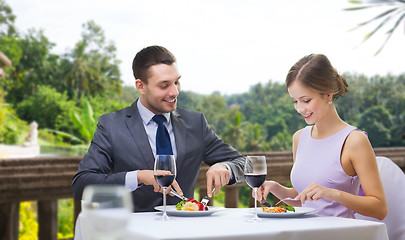 Image showing smiling couple eating appetizers at restaurant