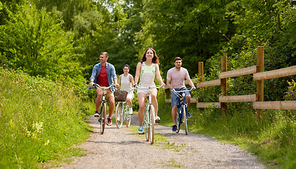 Image showing happy friends riding fixed gear bicycles in summer