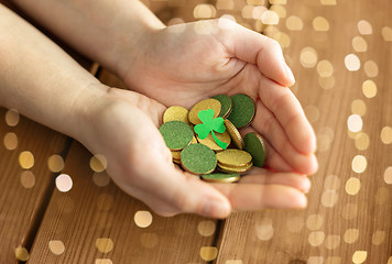 Image showing hands with golden coins and shamrock leaf