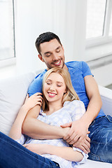 Image showing happy couple sitting on sofa and hugging at home