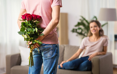 Image showing woman and man with bunch of roses behind his back