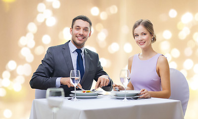 Image showing smiling couple eating appetizers at restaurant