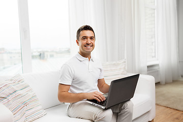 Image showing happy man with laptop computer at home