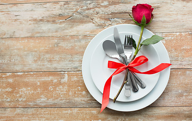 Image showing red rose flower on set of dishes