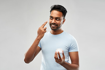 Image showing happy indian man applying cream to face