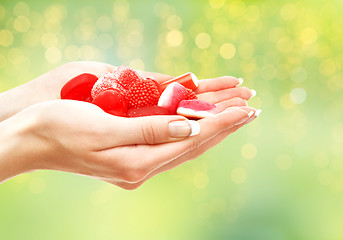 Image showing close up of hands holding red jelly candies