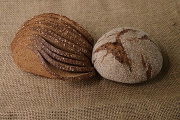 Image showing slices and loaf of rye bread on burlap