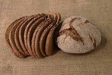 Image showing slices and loaf of rye bread on burlap