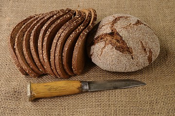 Image showing slices and  loaf of rye bread and finnish knife puukko on burlap