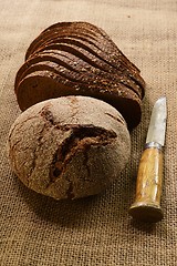 Image showing slices and  loaf of rye bread and finnish knife puukko on burlap