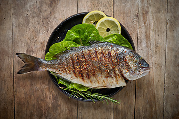 Image showing Grilled fish on black plate