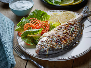 Image showing grilled fish on wooden kitchen table