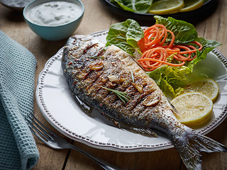 Image showing grilled fish on wooden kitchen table
