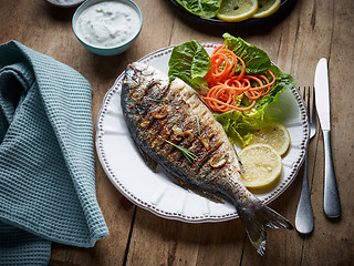 Image showing grilled fish on wooden kitchen table