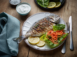 Image showing grilled fish on wooden kitchen table