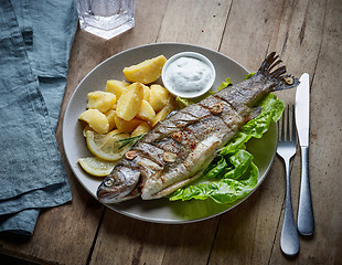 Image showing grilled fish on wooden kitchen table