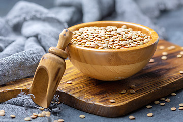 Image showing Dry brown lentils in a wooden bowl.