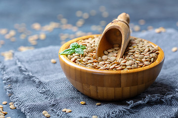 Image showing Brown organic dried lentils in a wooden bowl.