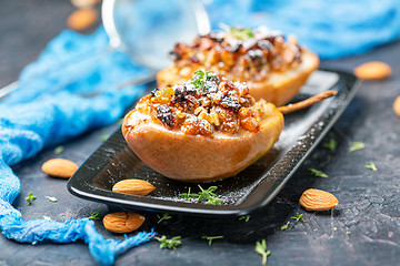 Image showing Baked pear with raisins, nuts and honey.