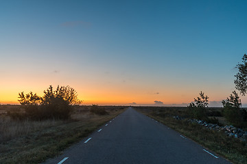 Image showing Sunrise at a country road in a plane barren landscape