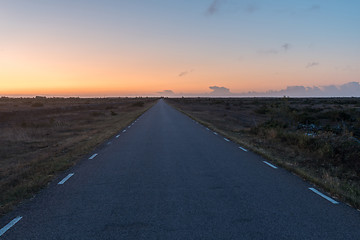 Image showing Morning with colored sky by a road in a plain barren grassland