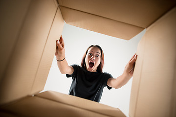 Image showing Woman unpacking and opening carton box and looking inside