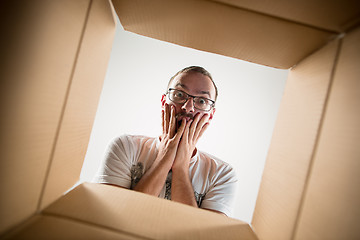 Image showing Man unpacking and opening carton box and looking inside