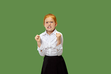 Image showing Portrait of angry teen girl on a green studio background