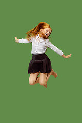 Image showing Young happy caucasian teen girl jumping in the air , isolated on green background