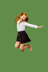 Image showing Young happy caucasian teen girl jumping in the air , isolated on green background