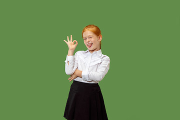 Image showing The happy teen girl standing and smiling against p green background.