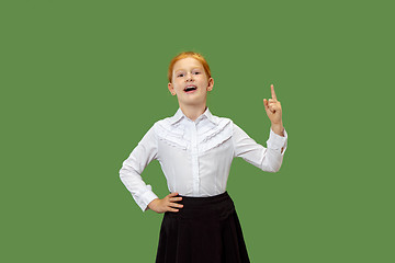 Image showing The happy teen girl standing and smiling against green background.