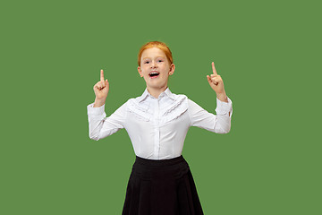 Image showing The happy teen girl standing and smiling against green background.