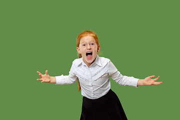 Image showing The young emotional angry teen girl screaming on green studio background