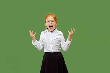 Image showing The young emotional angry teen girl screaming on green studio background