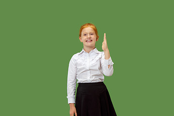 Image showing The happy teen girl standing and smiling against green background.