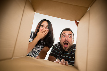 Image showing The couple unpacking and opening carton box and looking inside