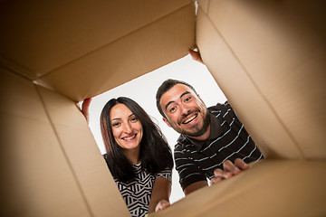 Image showing The couple unpacking and opening carton box and looking inside