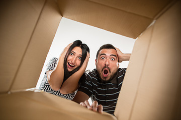 Image showing The couple unpacking and opening carton box and looking inside
