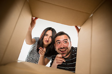 Image showing The couple unpacking and opening carton box and looking inside