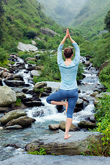 Image showing Woman in yoga asana Vrikshasana tree pose at waterfall outdoors