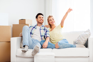 Image showing happy couple with cardboard boxes at new home