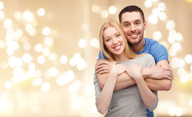 Image showing smiling couple hugging over festive lights