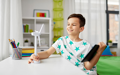 Image showing boy with tablet and model of wind turbine at home