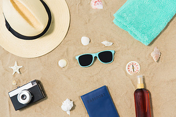 Image showing camera, passport, sunglasses and hat on beach sand