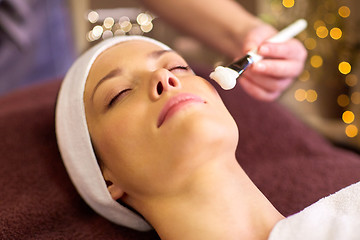 Image showing beautician applying facial mask to woman at spa