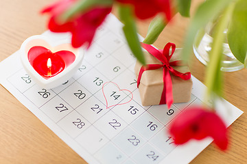 Image showing gift box, calendar sheet and flowers on table