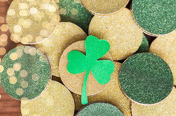 Image showing close up of golden coins and green shamrock leaf