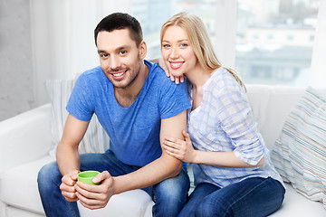 Image showing happy couple sitting on sofa and hugging at home