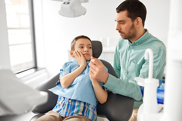 Image showing father supporting son at dental clinic